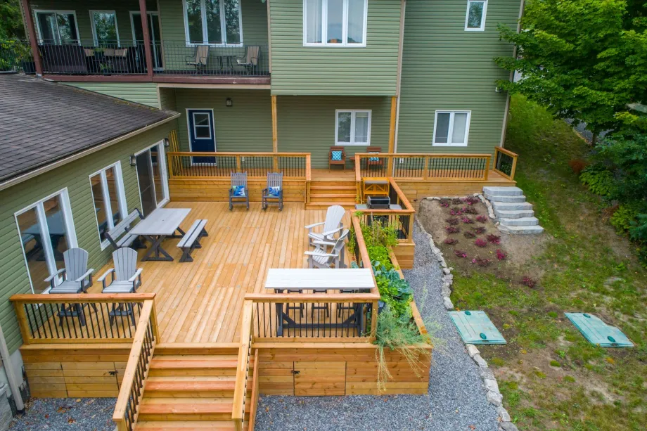 Wooden deck with chairs and tables next to a house
