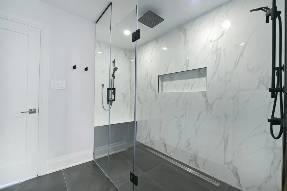 Bathroom with a glass-enclosed shower and marble walls