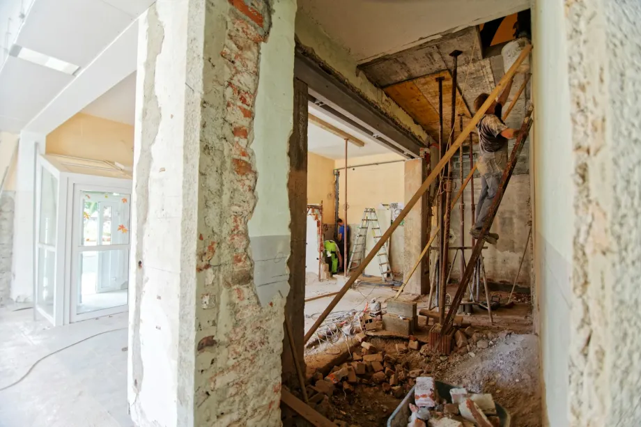 Man on a ladder in a room under renovation