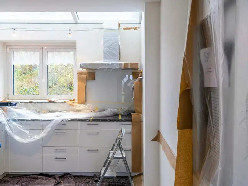 Kitchen during renovation, cabinets wrapped in protective paper